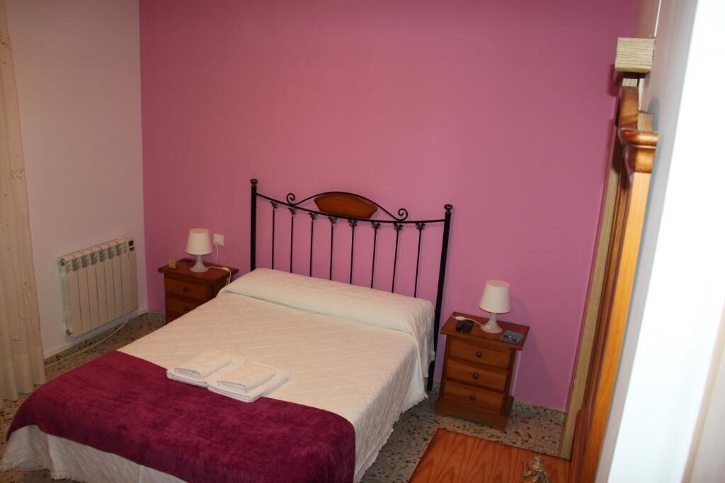 Una camera da letto con un letto singolo, due comodini e un armadio in legno.