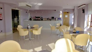A modern hotel lobby with a bar area, seating arrangements, and a fire extinguisher. - Motel Abalo (Catoira)