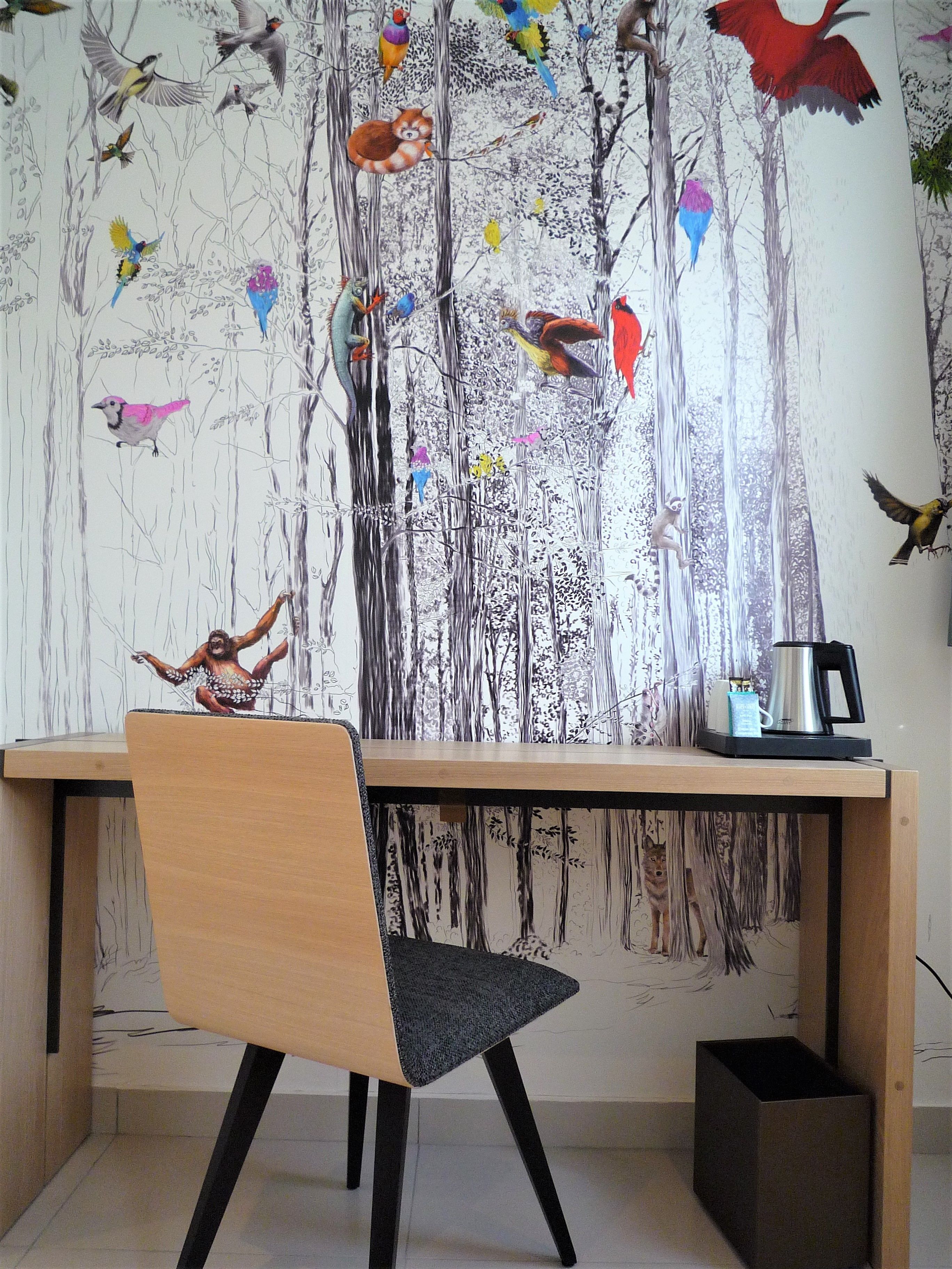 A modern office space with a wooden desk, a chair, and a coffee maker.