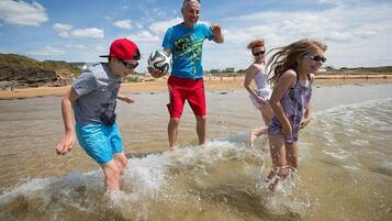A beach scene with people playing in the water.