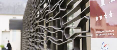A modern building facade with a unique geometric metal design.