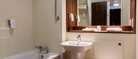 Un baño moderno con bañera, lavamanos e inodoro.