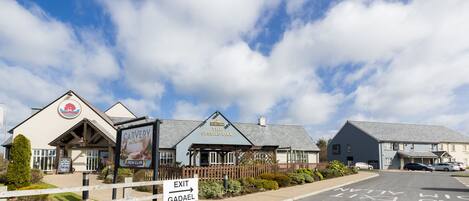 Une rangée de bâtiments dont les enseignes indiquent « Restaurant proposant de la viande rôtie » et « The Sessile Oak ».