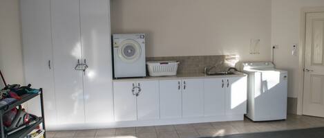 A laundry room with a washing machine, dryer, and stacked laundry baskets.