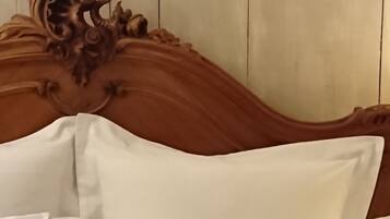 A bed with a wooden headboard, white and brown pillows, and a dark brown pillow with tassels.