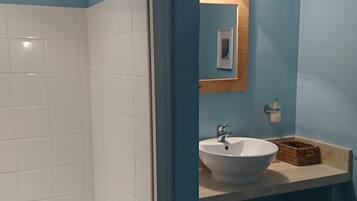 A bathroom with a shower, a sink, and a mirror.