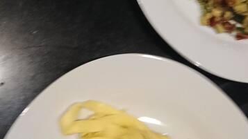 Two plates of food on a dark surface.