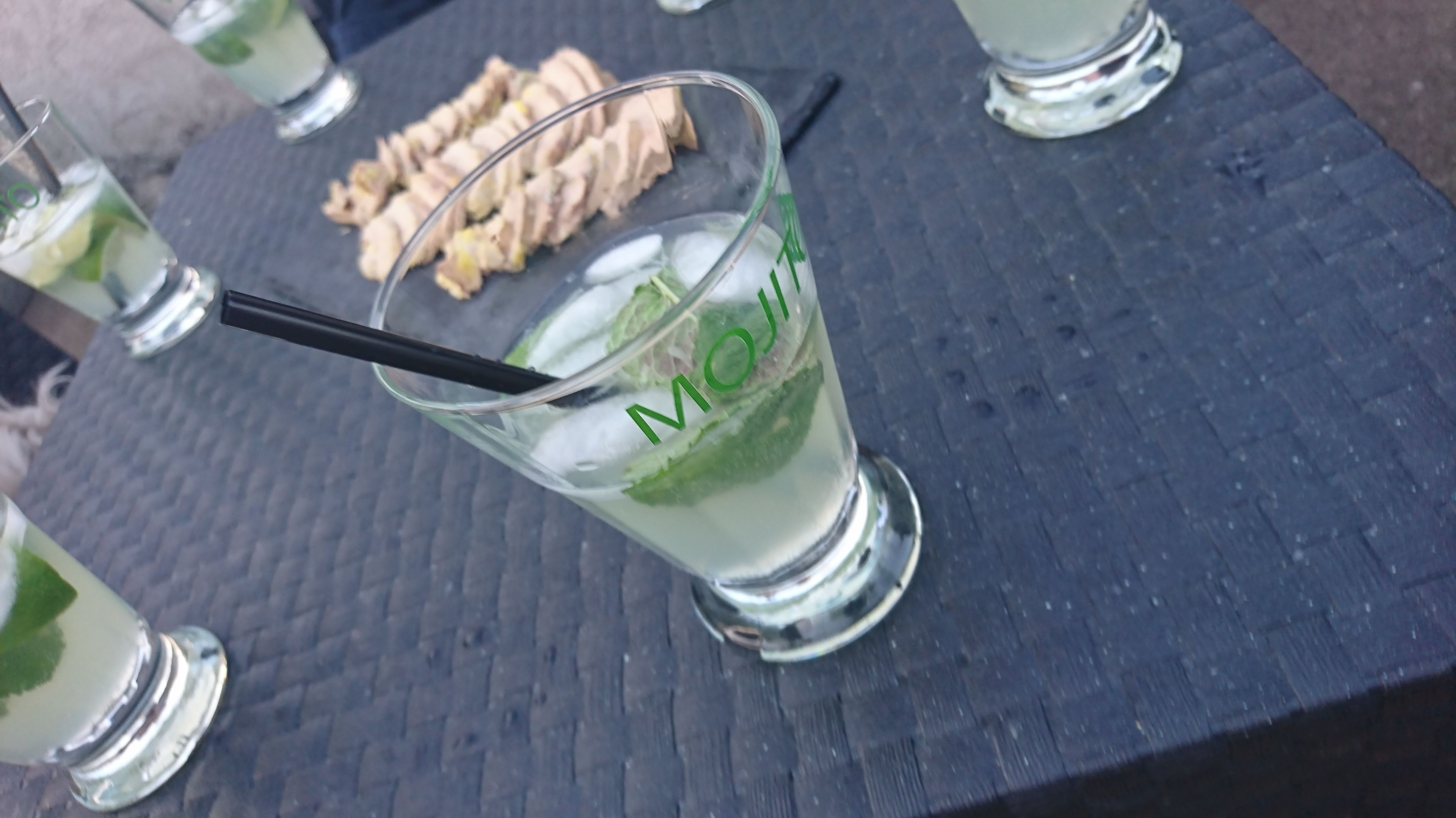 Een mojito met muntblaadjes op een arduinen tafel.