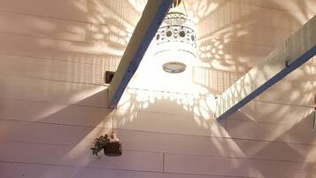 A hot tub with a blue light, a ceiling fan, and a wall-mounted light fixture.