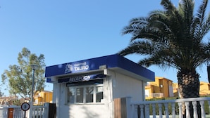 A small building with a blue awning labeled "CAMPING TAURO RECEPTION".