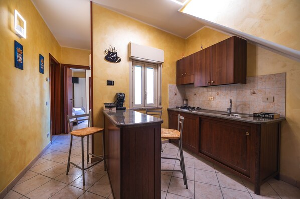Una cocina con armarios de madera, una barra y una ventana.