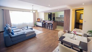 Un salon moderne comprenant un canapé, une table à manger et un coin cuisine.