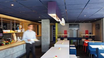 A modern restaurant with a long counter, seating area, and a bar.