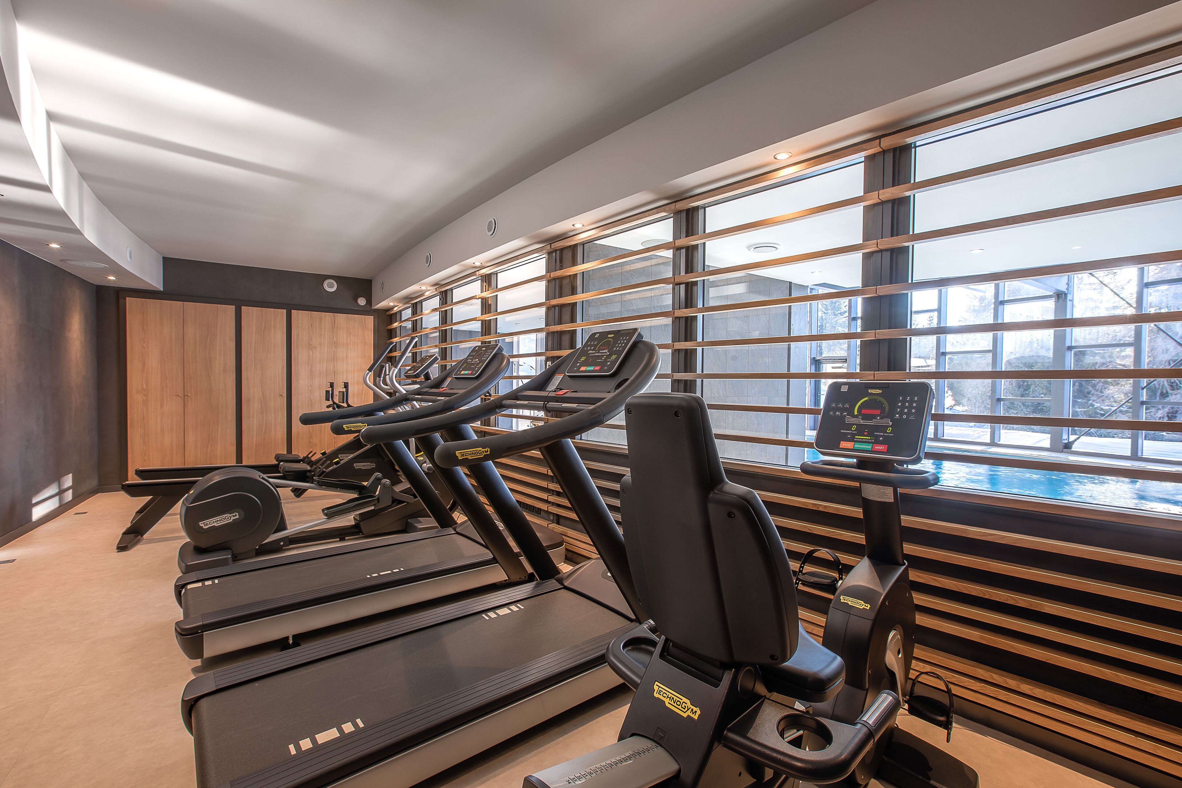 A gym with treadmills, ellipticals, and a rowing machine.