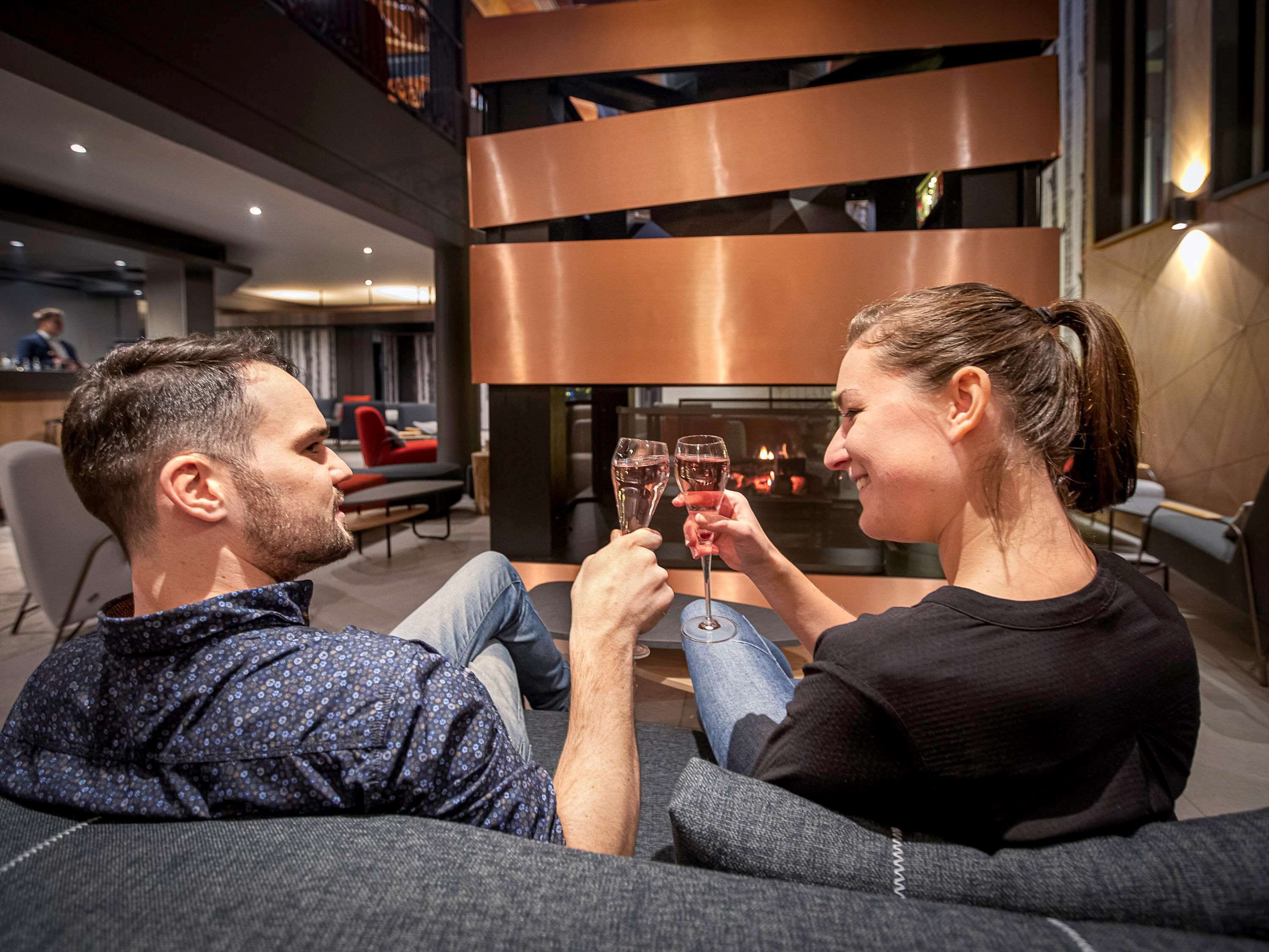 A modern interior with a sofa, a fireplace, and a bar area.