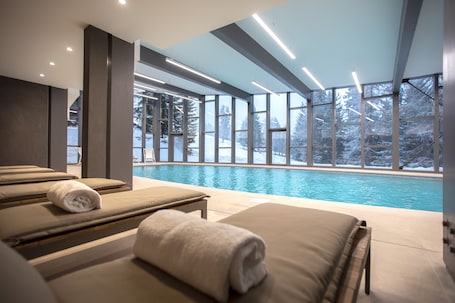 Una piscina techada, sillones reclinables de piscina