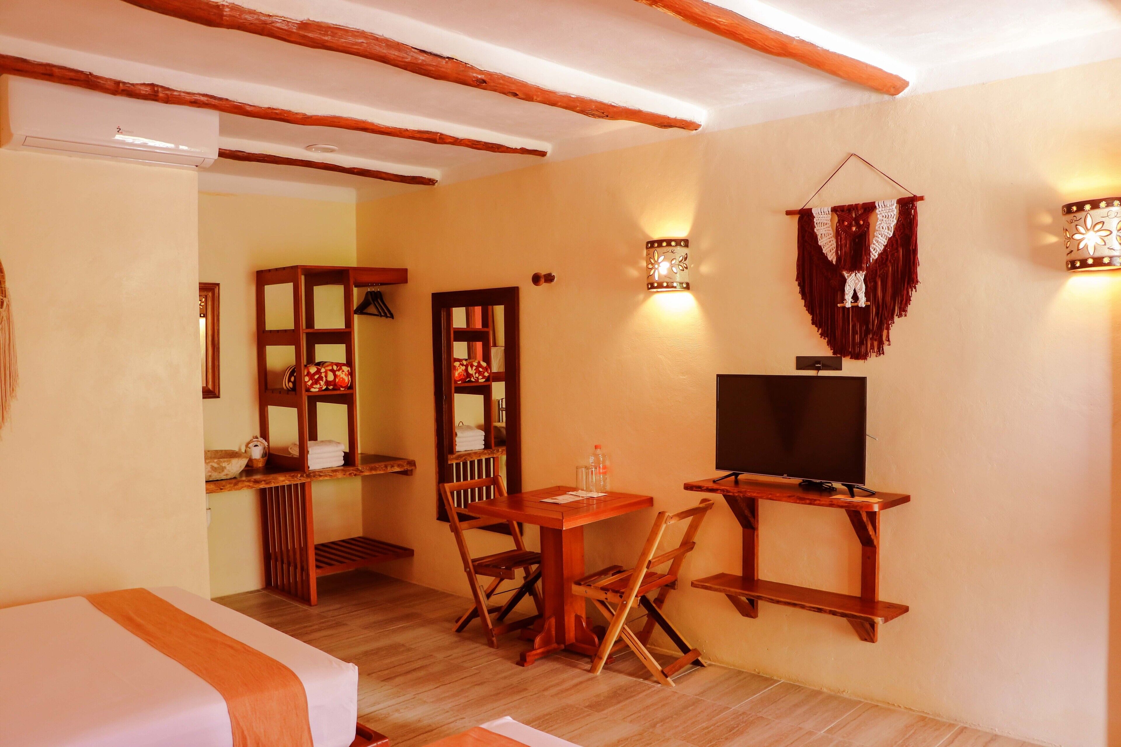 A room with a bed, wooden furniture, a TV, and wall-mounted lights.