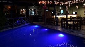 Un área de piscina interior con bar y asientos.