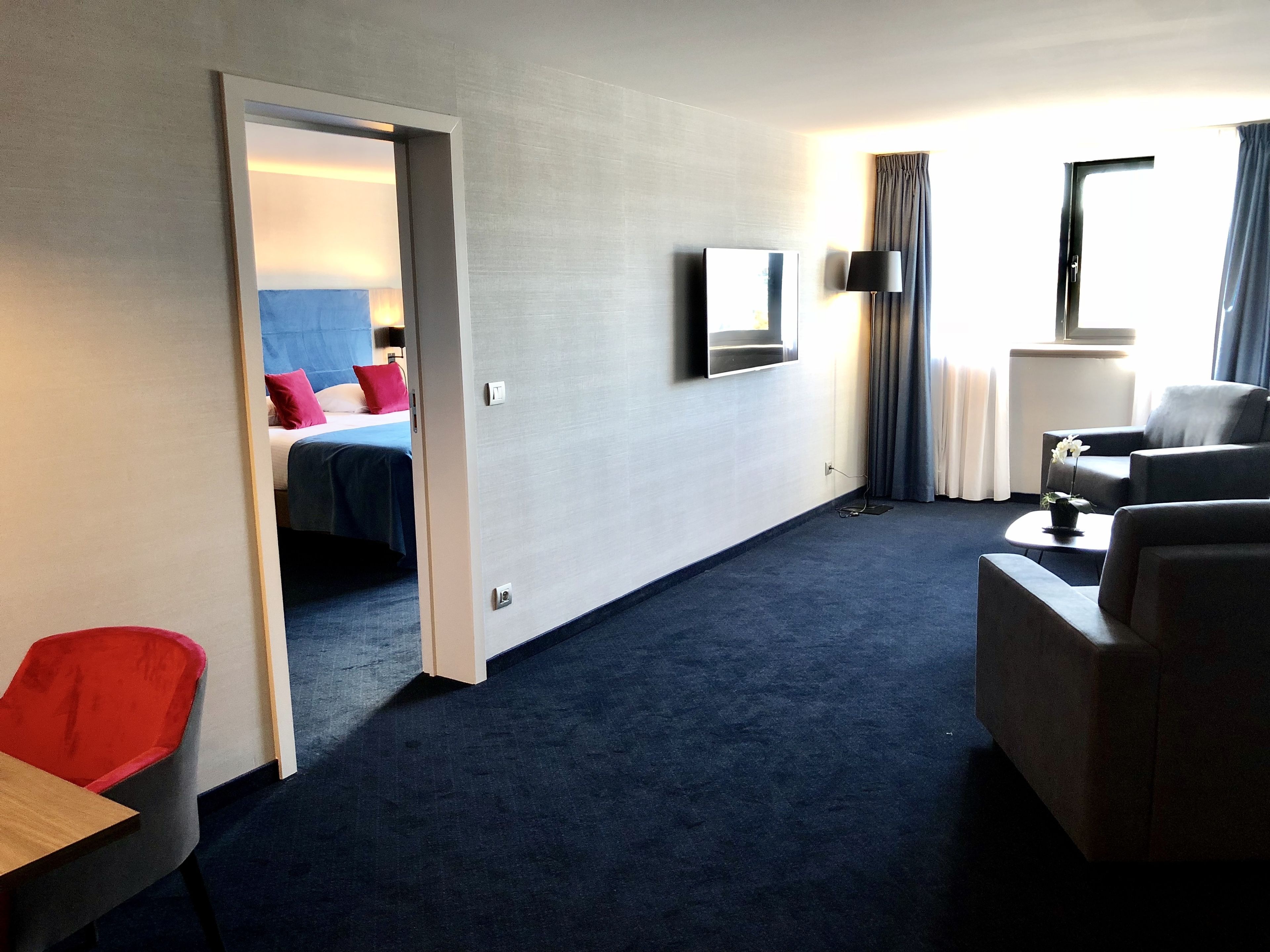 Une chambre d’hôtel équipée d’un lit, d’une télévision, d’un bureau et d’un coin salon.
