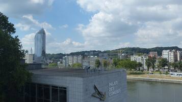 Une vue d’un bâtiment sur lequel on peut lire l’inscription « Palais des Congrès », avec un gratte-ciel moderne en arrière-plan.