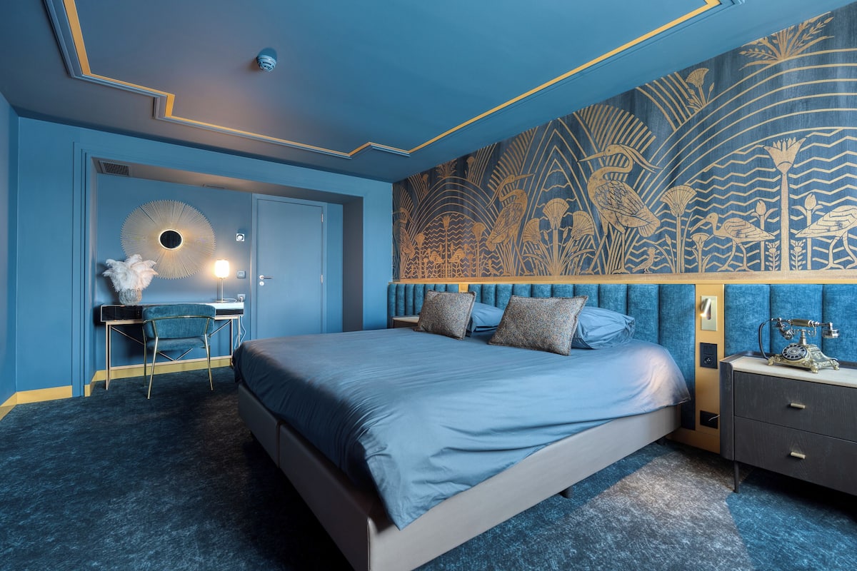 Une chambre à coucher avec un lit, un bureau et une table de chevet.