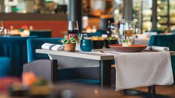 Un ambiente de restaurante con mesas dispuestas para comer, mostrando una variedad de platos y bebidas.