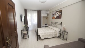 Un dormitorio con cama, mesita de noche y escritorio con silla.