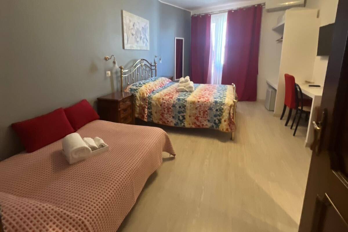A hotel room with two beds, a desk, and a chair.