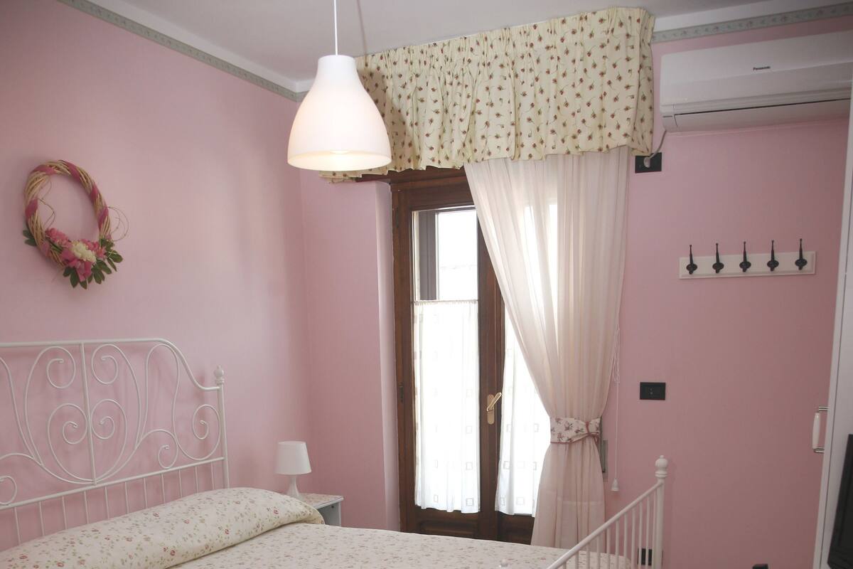 A bedroom with a bed, a desk, and a chair.