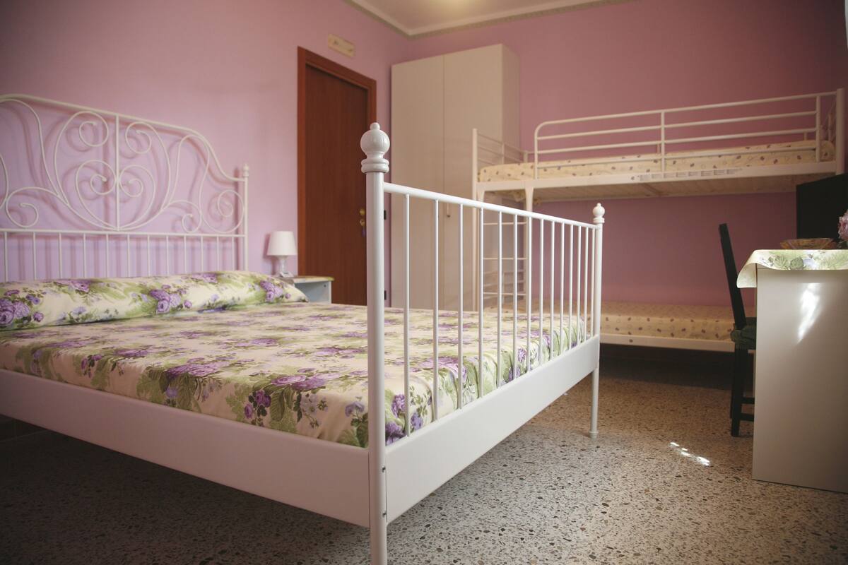 A bedroom with a bunk bed, a desk, and a chair.