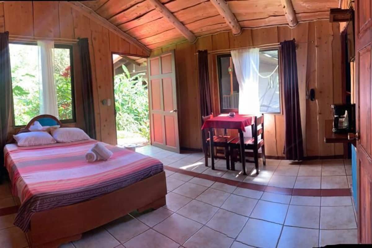 Una habitación de madera con una cama, una mesa y sillas.