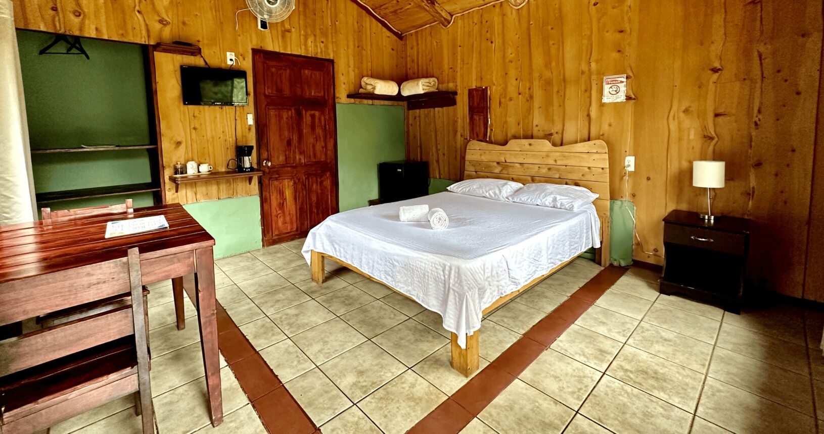 Une pièce en bois avec un lit, un bureau et une chaise.