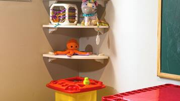 A child's play area with shelves, toys, and a chalkboard.