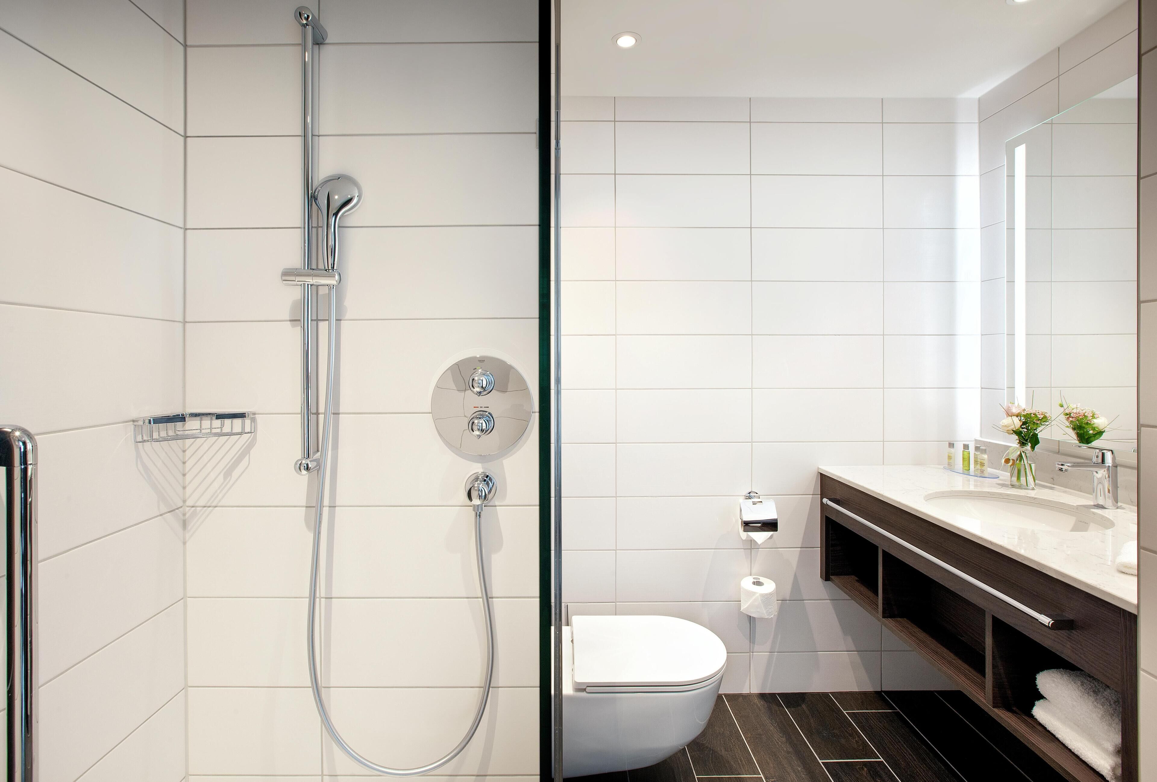 A modern bathroom with a shower, toilet, and vanity.