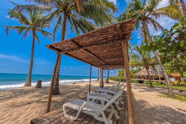 På stranden, strandtelt (inkludert), solsenger og parasoller