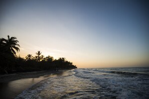 Na praia, barracas de praia de cortesia, espreguiçadeiras, guarda-sóis
