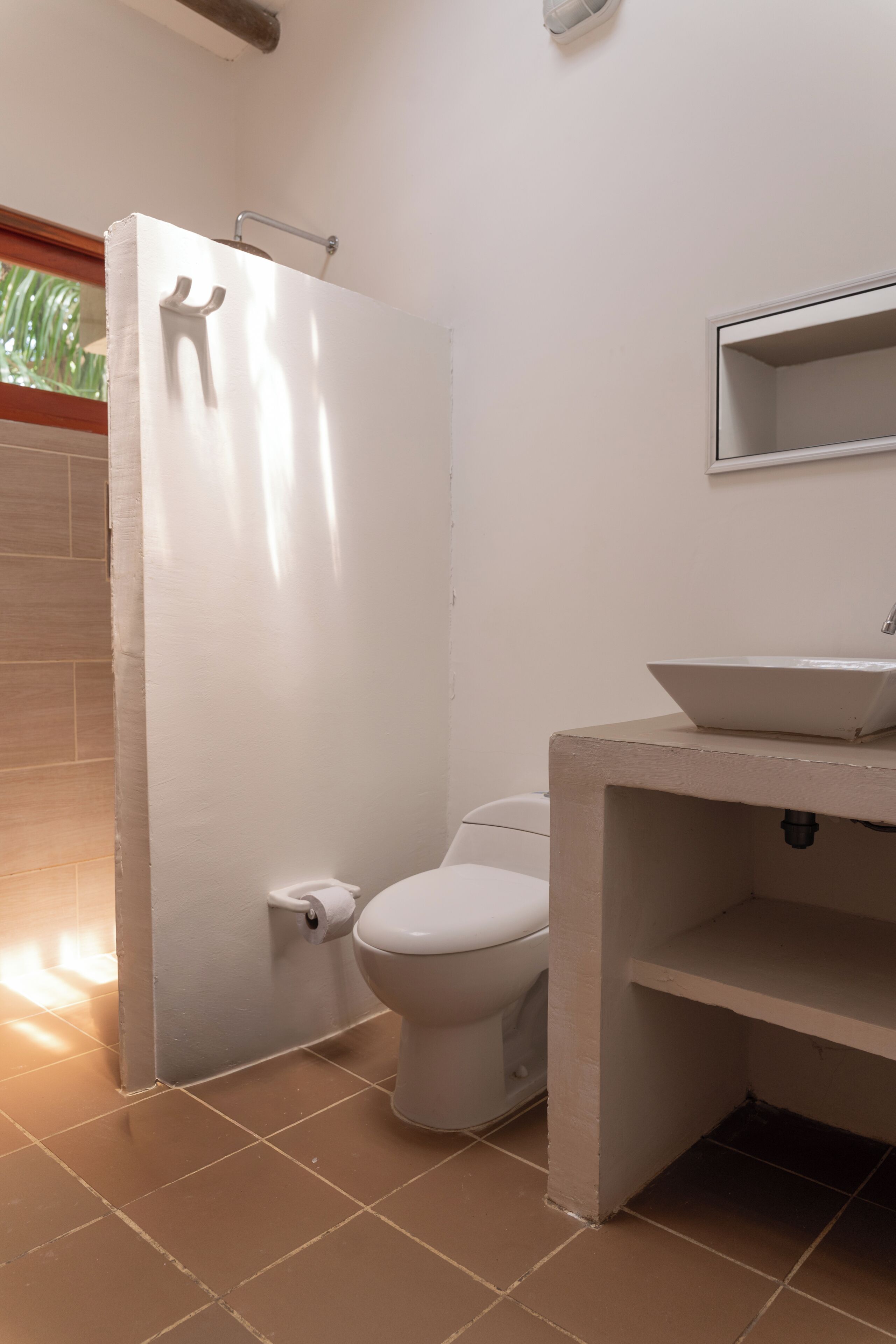A bathroom with a toilet, a white sink, and a shower enclosure.