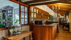Un intérieur en bois avec un comptoir de cuisine, des poutres apparentes et un lustre.