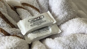 A white, fluffy towel with a small white tag attached to it.