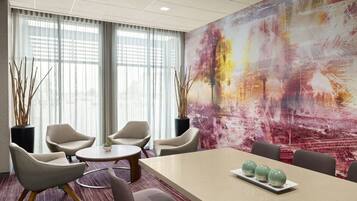 A modern conference room with a large table, several chairs, and a vibrant abstract painting on the wall.