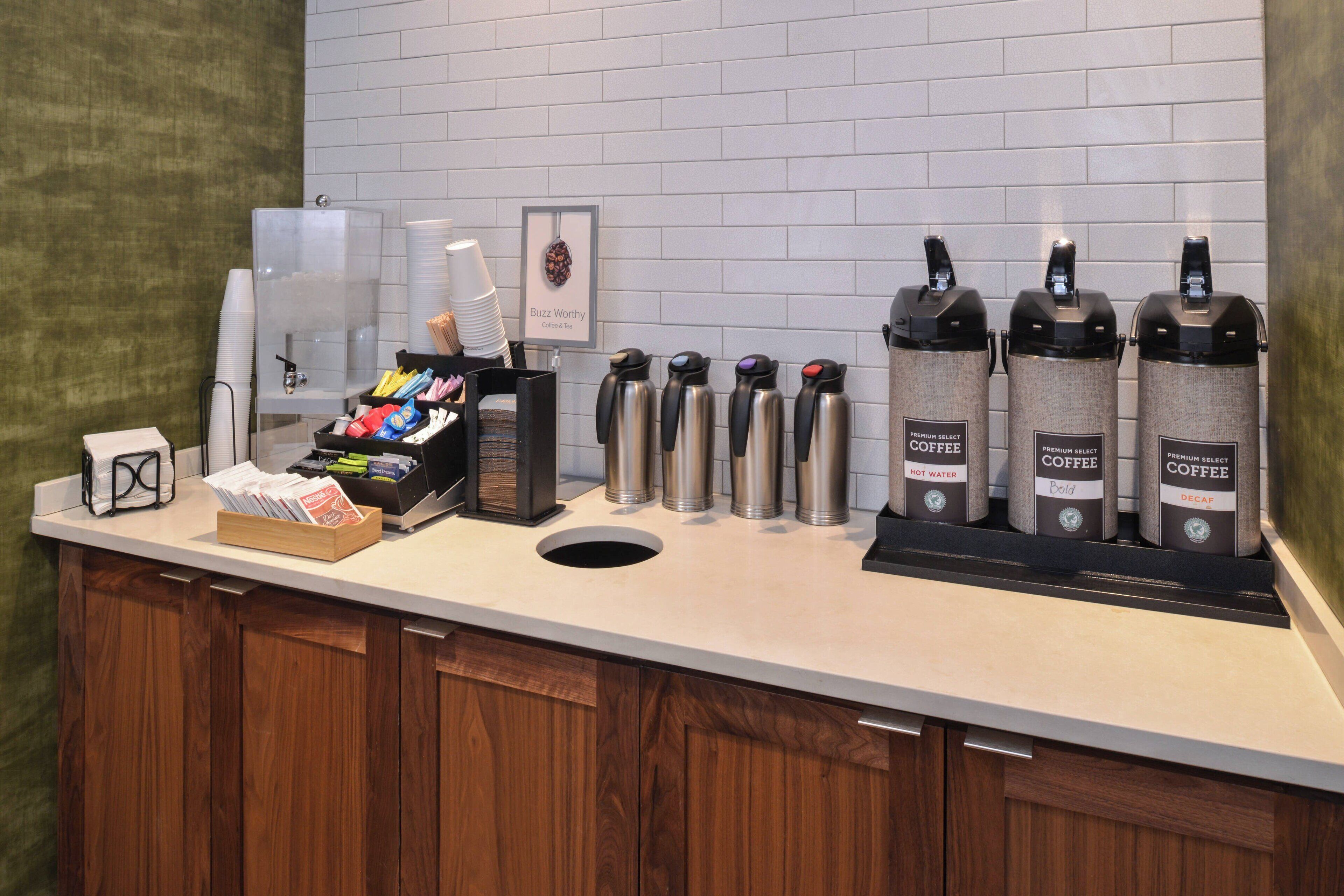 A coffee station with multiple coffee dispensers and a coffee machine.