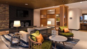 Un área de descanso moderna con sofá, sillones, una mesa de centro y una chimenea.