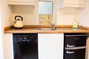 A compact kitchen with a kettle, a blender, and a refrigerator. - Plover Cottage (Huddersfield)