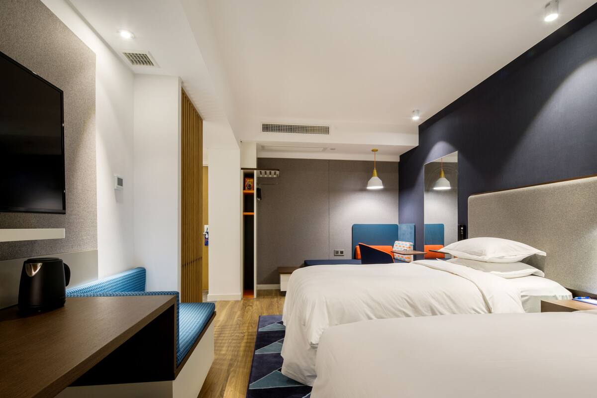 Una camera d'albergo moderna con un ampio letto, una scrivania e una televisione.