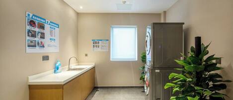 A compact kitchen with a sink, countertop, and a refrigerator.