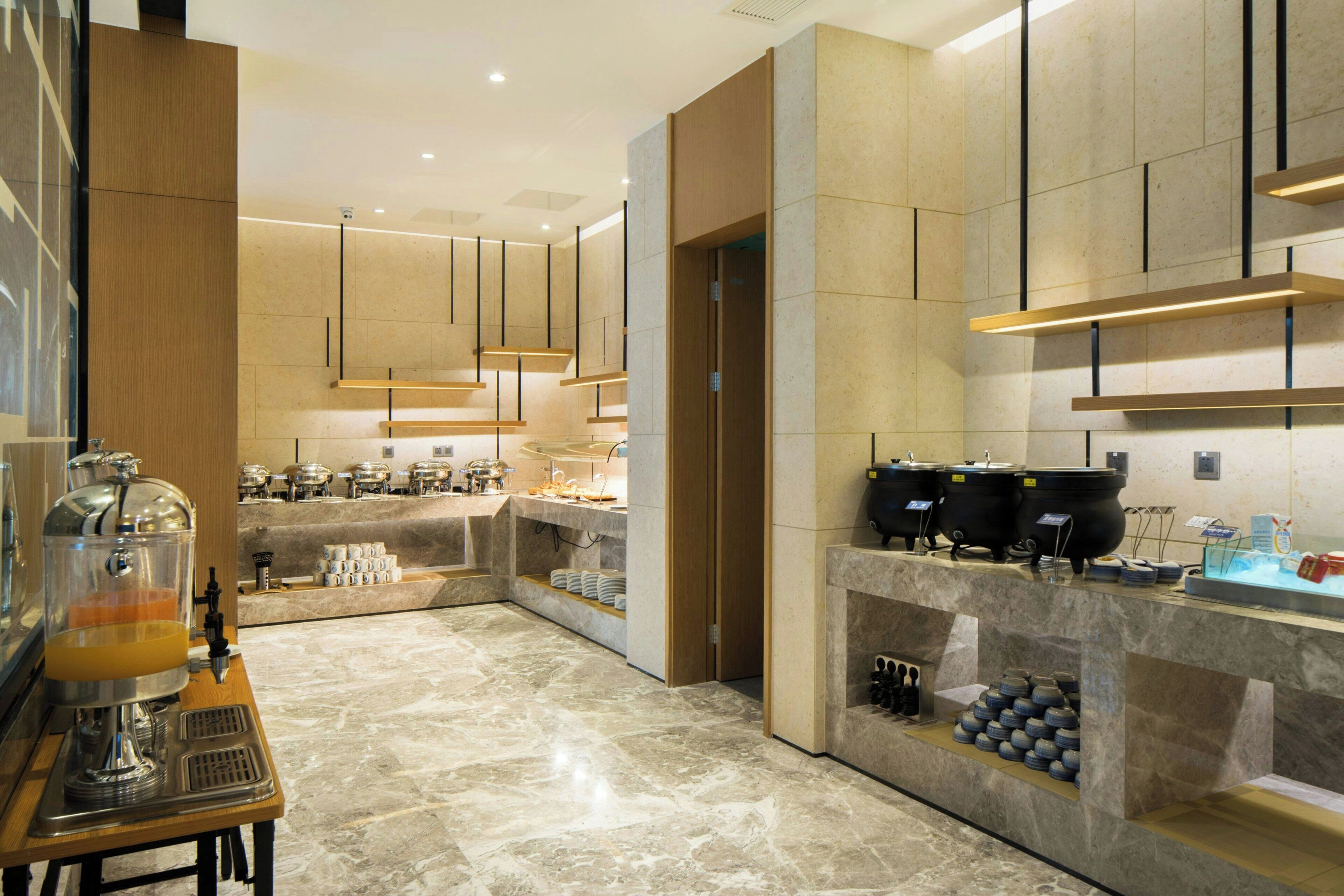 Una cocina moderna con encimeras de mármol, estación de café y dispensador de zumo.