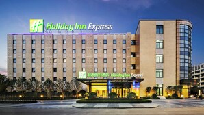 A Holiday Inn Express hotel with a modern brick facade, multiple floors, and a well-lit entrance.