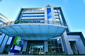 A Holiday Inn Express building with a modern design, featuring a prominent entrance and a glass facade. - Holiday Inn Express Asuncion Aviadores by IHG (Asunción)