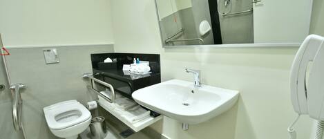 Un baño moderno con inodoro, lavabo y espejo.
