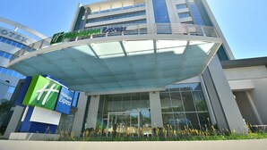 A Holiday Inn Express building with a modern glass facade and a covered walkway. - Holiday Inn Express Asuncion Aviadores by IHG (Asunción)